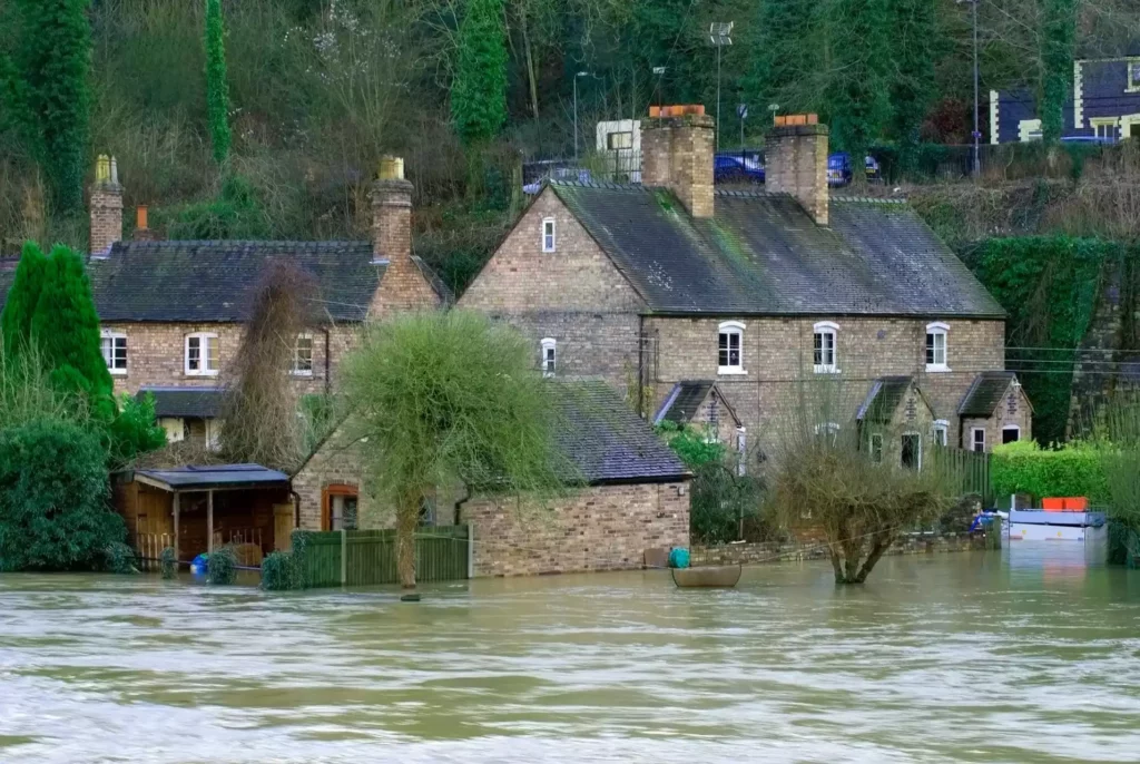 A row of brick houses with several feet of flood waters covering the majority of the ground floor.