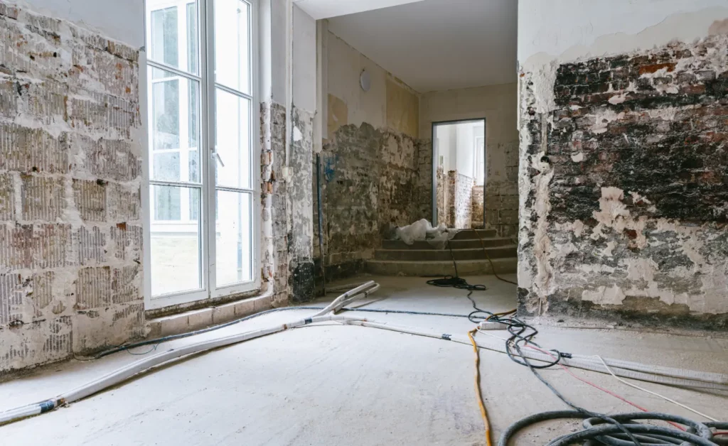 A room with water damage to the walls and floor.